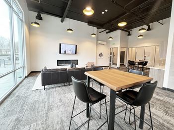A communal area with a table and chairs and a living room with a tv
